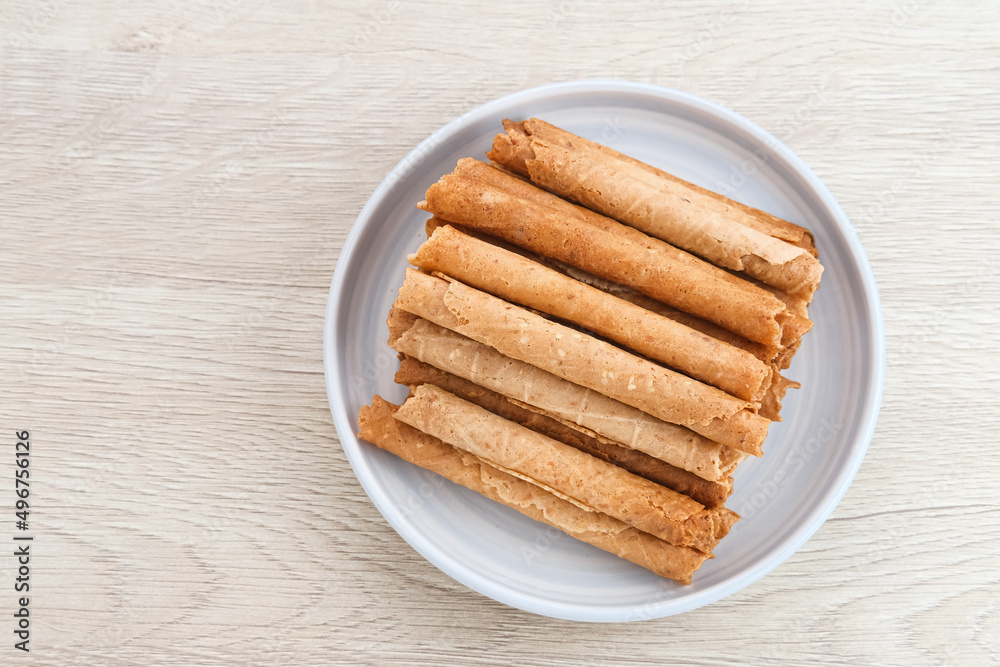 Waffle egg rolls or semprong cake, a traditional Indonesian snack with a unique shape like a layered pipe, served on a white plate. Selected focus.
Waffle egg rolls or semprong cake, a traditional Indonesian snack with a unique shape like a layered pipe, served on a white plate. Selected focus.