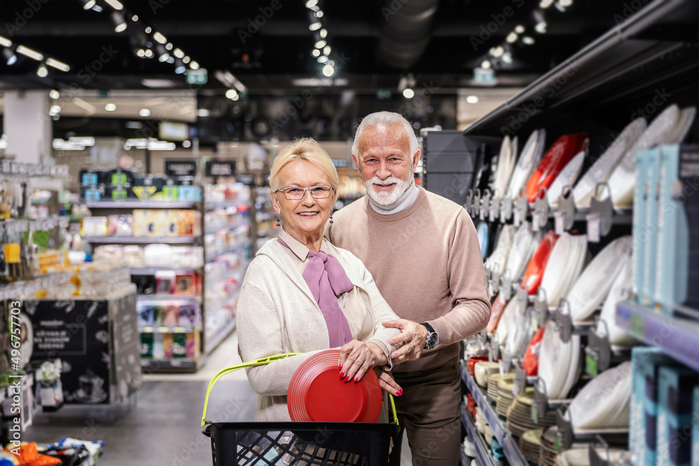 A senior couple buying utensils for home at the supermarket.
