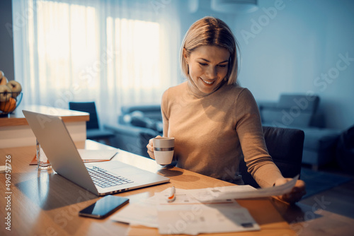 A happy woman doing household budget at her cozy home. photo