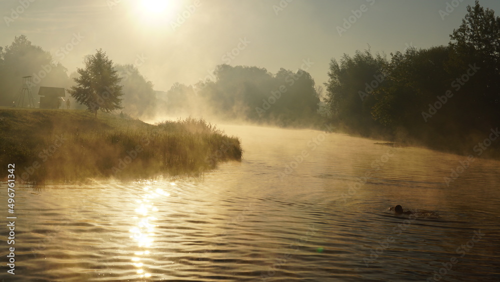 colorful summer morning with golden light and fog between hills