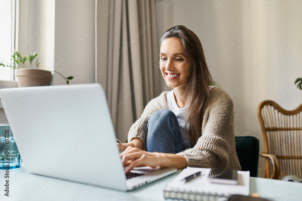 Smiling freelancer working on laptop at home