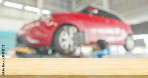 Empty wood table top with car service centre auto repair workshop blurred background