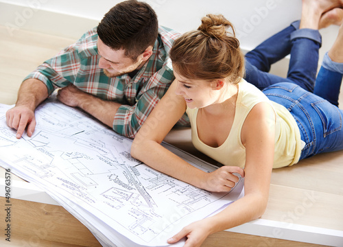 Theyve got big plans for their new home. Shot of a young couple inspecting the building plans for their new home.