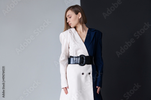 Fashionable woman standing against dual toned background