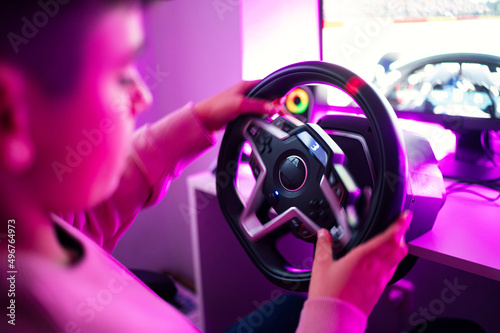 Boy playing video game with steering wheel simulator at home