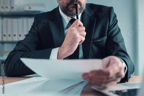 Fiduciary, agent carefully reading business papers in office photo