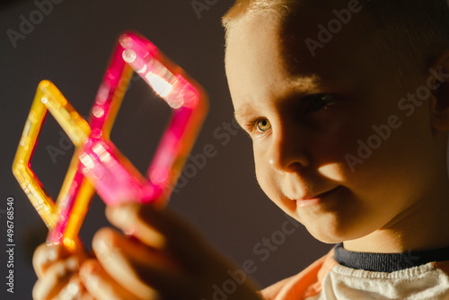 Smiling boy playing with magnetic tiles photo