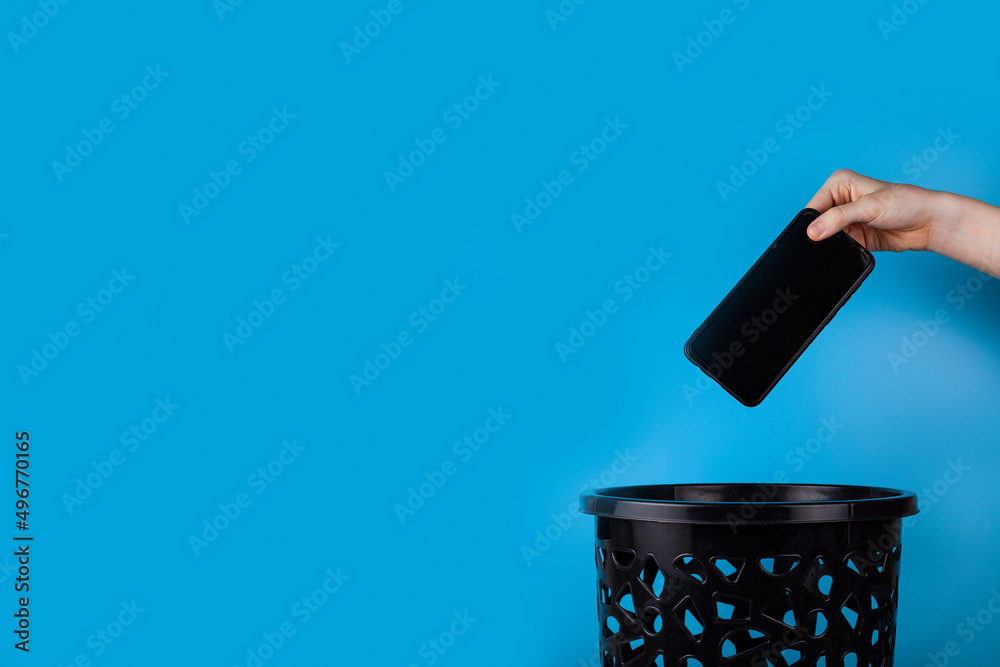 The smartphone is thrown into the trash for disposal The smartphone is thrown into the trash for disposal