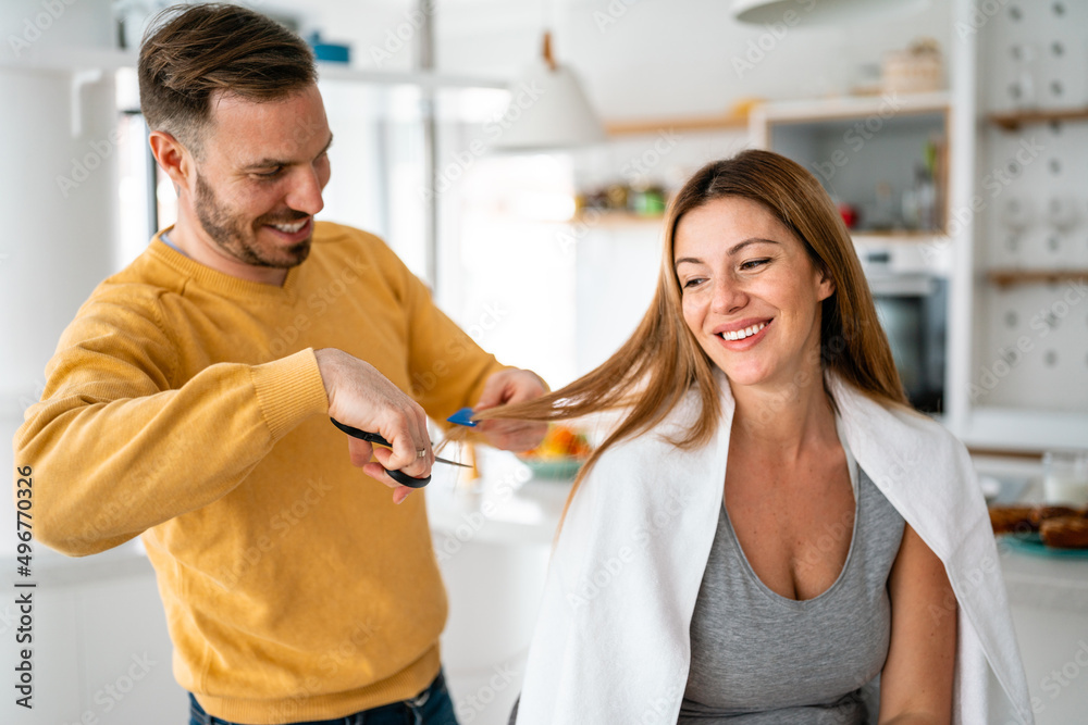 Couple having hair cut at home during quarantine coronavirus pandemic, online hairdressing on tablet