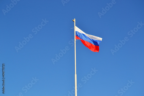 The flag of Russia is flying in the wind against the blue sky,banner,