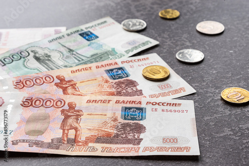 Russian rubles as banknotes and coins on a dark background. Financial crisis, ruble devaluation concept. Close-up view.