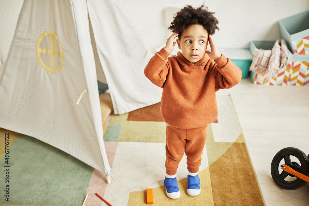 Full length portrait of cute African American toddler looking surprised