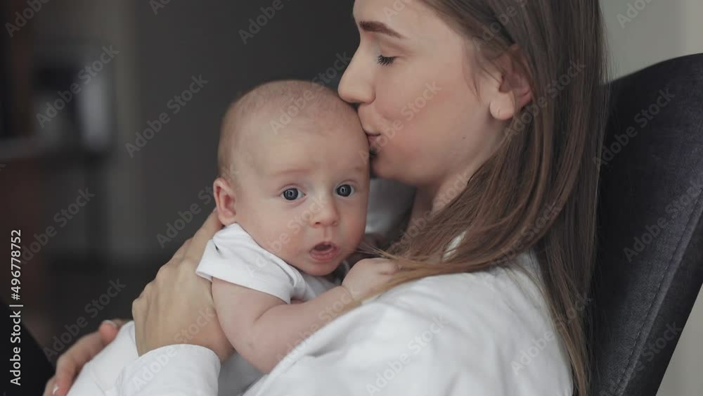 Happy mother holding and kissing her newborn baby Happy mother holding and kissing her newborn baby