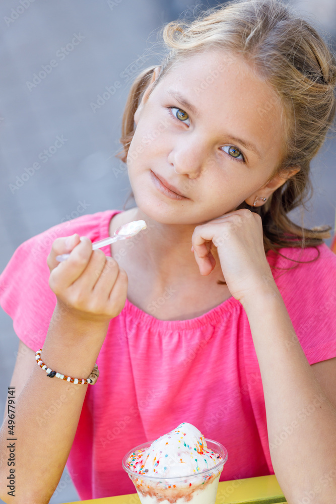 Caucasian girl blonde in a pink blouse with ice cream Caucasian girl blonde in a pink blouse with ice cream