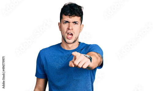 Young hispanic man wearing casual t shirt pointing displeased and frustrated to the camera, angry and furious with you