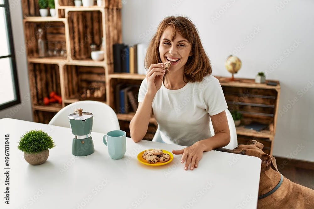 Young caucasian woman having breakfast sitting on table at home