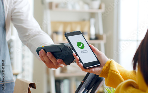 Customer using smartphone for NFC payment at cafe restaurant, cashless, contactless technology and money transfer concept photo