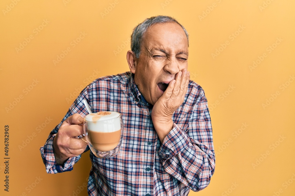 Handsome senior man with grey hair drinking a cup coffee laughing and embarrassed giggle covering mouth with hands, gossip and scandal concept Handsome senior man with grey hair drinking a cup coffee laughing and embarrassed giggle covering mouth with hands, gossip and scandal concept