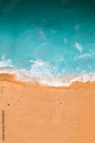 Aieral top view of a blue ocean waves and sandy coast photo