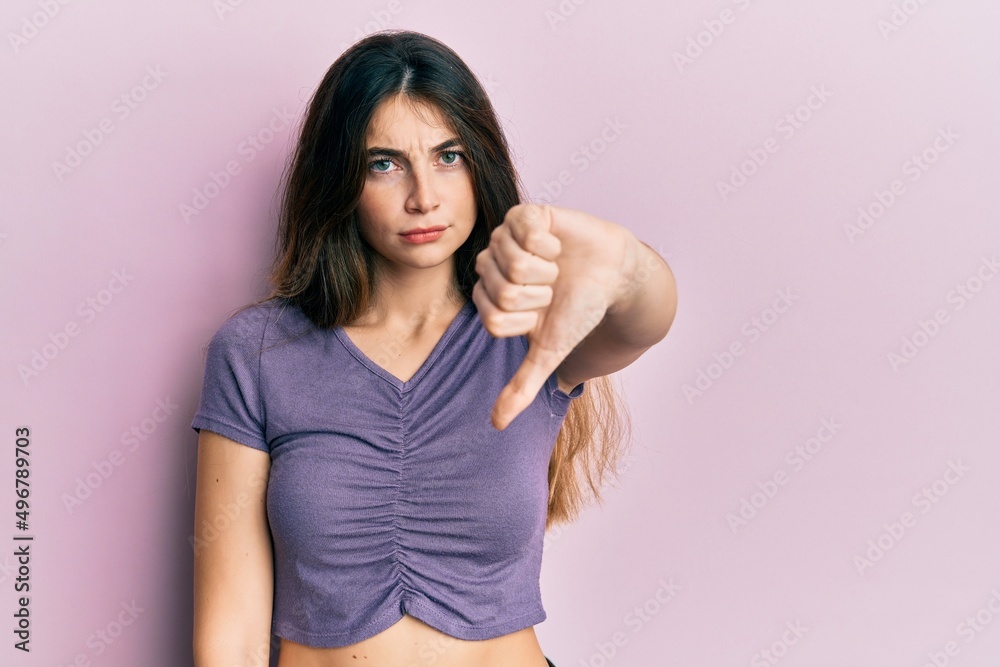 Young caucasian woman wearing casual clothes looking unhappy and angry showing rejection and negative with thumbs down gesture. bad expression.
