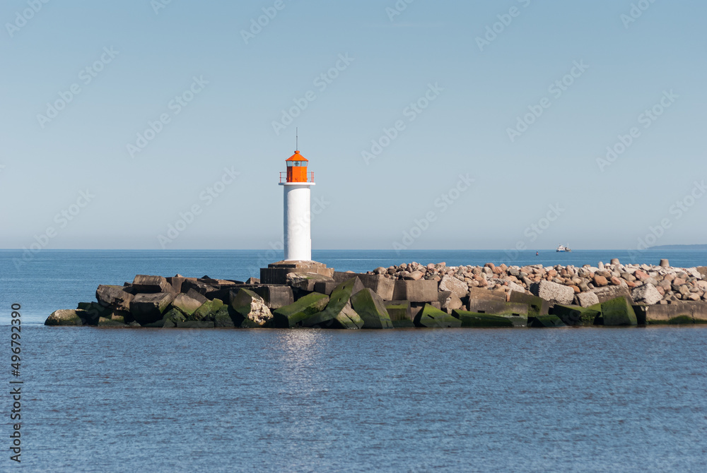Mole with lighthouse and concrete blocks in sunny day, Ventspils, Latvia.