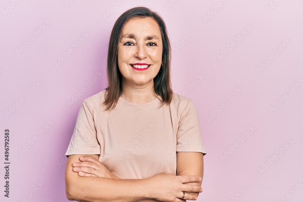Middle age hispanic woman wearing casual clothes happy face smiling with crossed arms looking at the camera. positive person. Middle age hispanic woman wearing casual clothes happy face smiling with crossed arms looking at the camera. positive person.