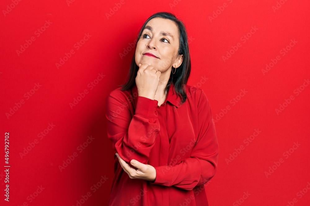 Middle age hispanic woman wearing casual clothes with hand on chin thinking about question, pensive expression. smiling and thoughtful face. doubt concept. Middle age hispanic woman wearing casual clothes with hand on chin thinking about question, pensive expression. smiling and thoughtful face. doubt concept.