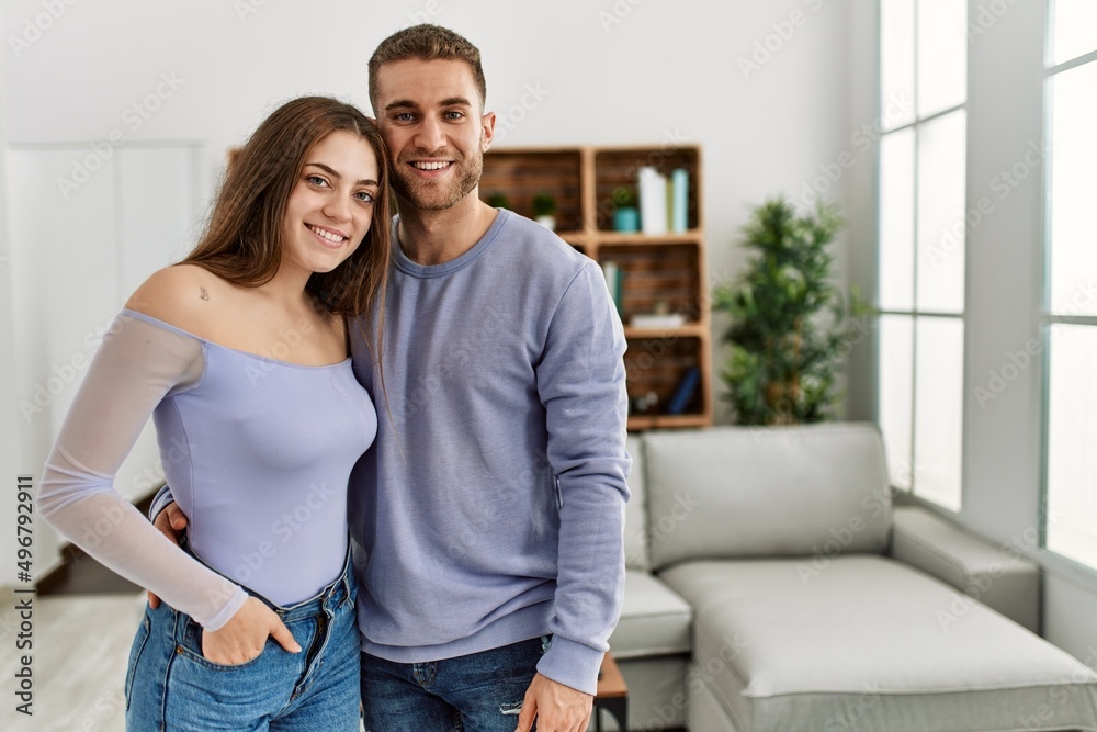 Young caucasian couple smiling happy standing at home.