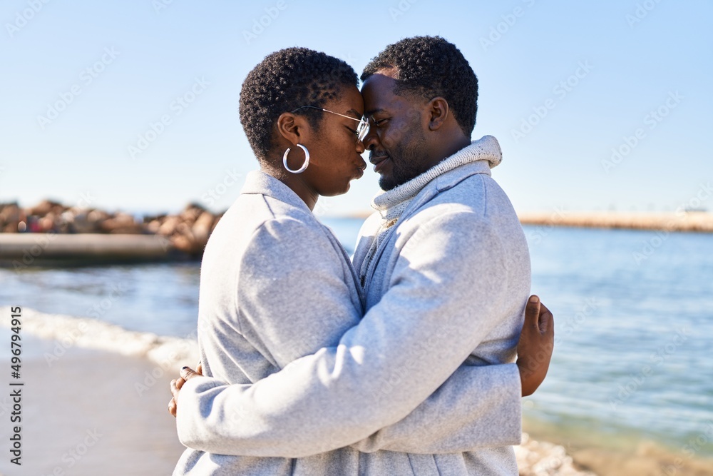 Man and woman couple hugging each other standing at seaside
