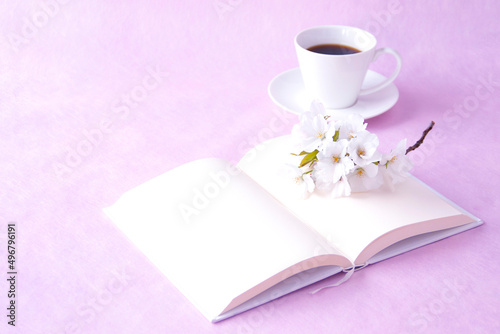 コーヒーと見開きの本と大島桜の花束（ピンクバック）