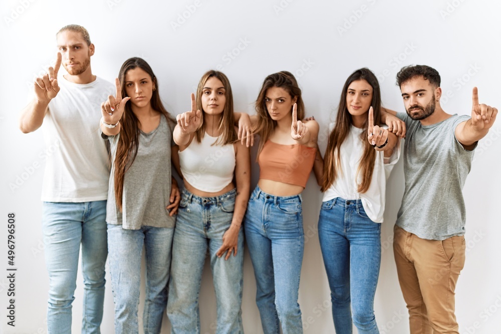 Group of young friends standing together over isolated background pointing with finger up and angry expression, showing no gesture Group of young friends standing together over isolated background pointing with finger up and angry expression, showing no gesture