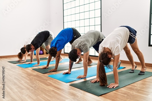 Group of young sporty people concentrate training yoga at sport center.