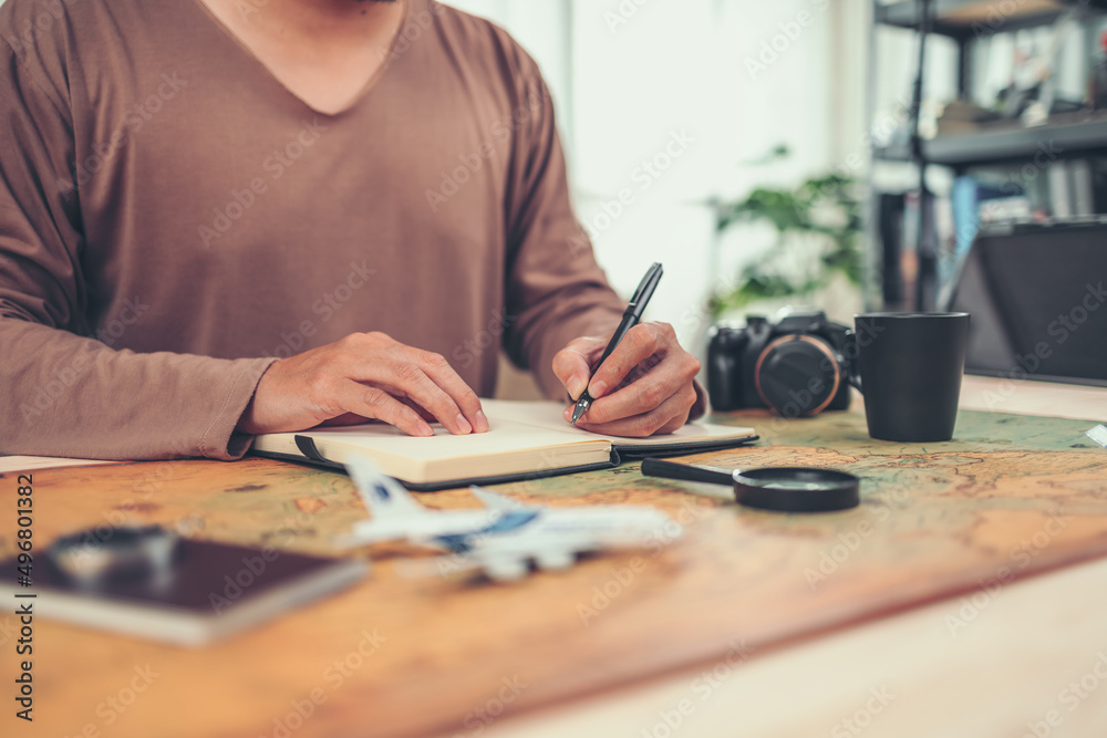 tourist writing on book before travel in vocation, holidays or long weeked on world map. Travel , Adventure and Discovery concept. tourist writing on book before travel in vocation, holidays or long weeked on world map. Travel , Adventure and Discovery concept.