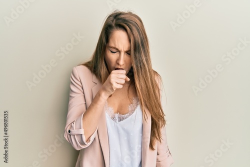 Young blonde woman wearing business jacket and glasses feeling unwell and coughing as symptom for cold or bronchitis. health care concept.