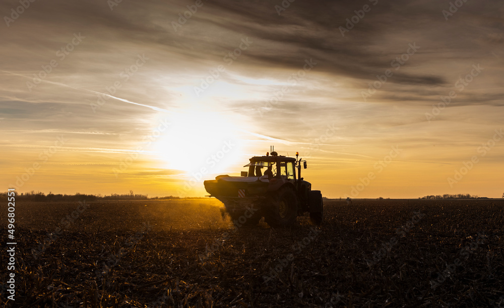 Tractor spreading artificial fertilizers in field