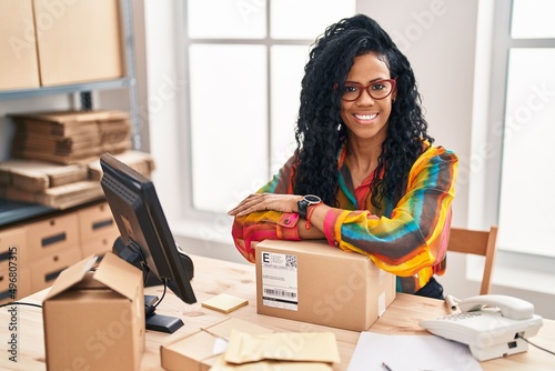 Canvas Print African american woman business worker leaning on package at office