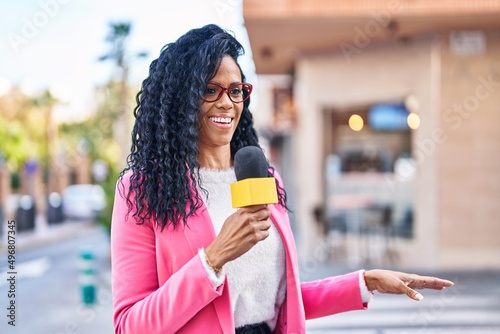 African american woman reporter working using microphone at street
