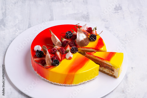 Closeup shot of a tasty cake topped with candies and fresh fruits photo