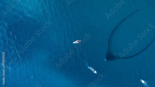 Aerial view of a few motorboat fishing with a net at El Golfo, Mediterranean Sea, Girona, Spain.