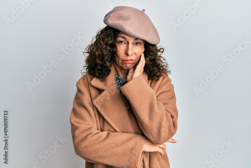 Middle age hispanic woman wearing french look with beret thinking looking tired and bored with depression problems with crossed arms.