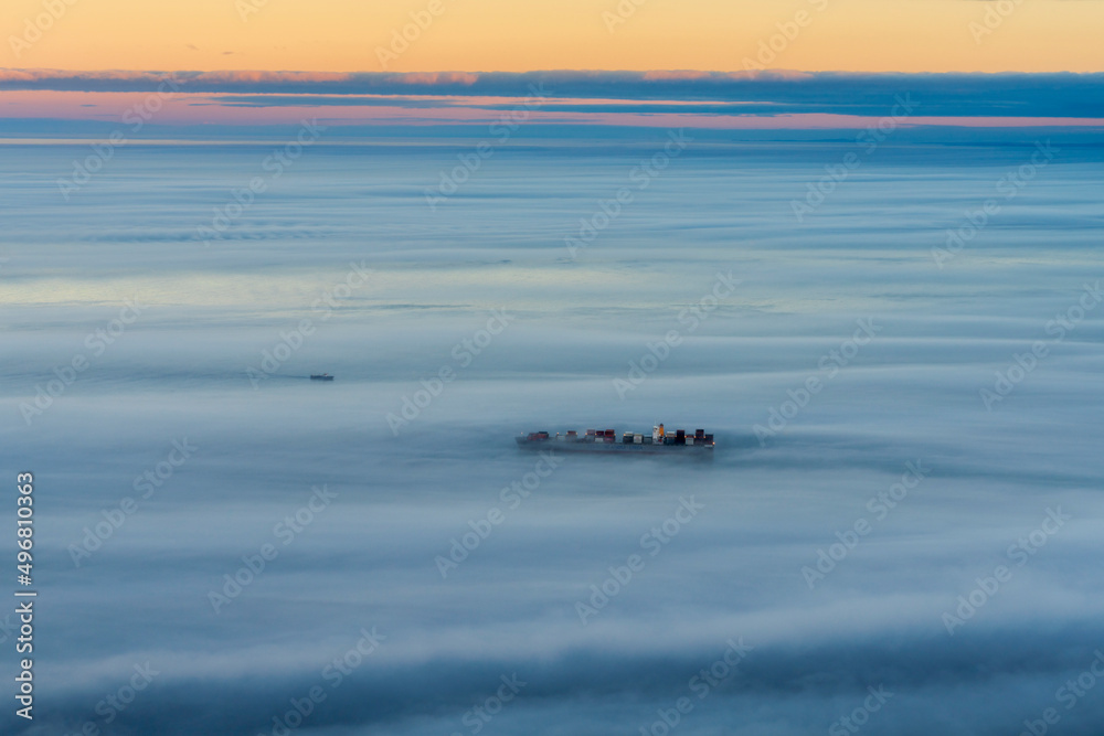 Aerial view of a cargo ship sailing goff Cape Town coastline during a foggy day, Cape Town, South Africa. Aerial view of a cargo ship sailing goff Cape Town coastline during a foggy day, Cape Town, South Africa.