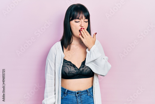 Young hispanic woman wearing lingerie bored yawning tired covering mouth with hand. restless and sleepiness.
