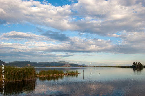 Scenic shot of Lake Massaciuccoli with mountains in the distance on a cloudy day, Tuscany, Italy photo