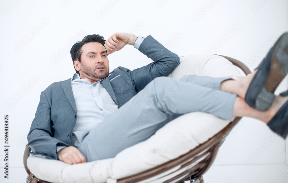 close up.the tired man relaxarea in a large round chair