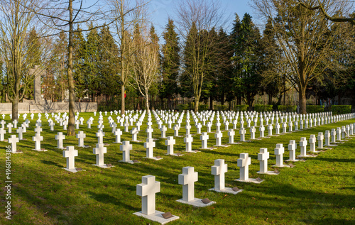 white crosses graveyard at Mortsel war cemetery with trees and cross monument in the background near Antwerp in Belgium