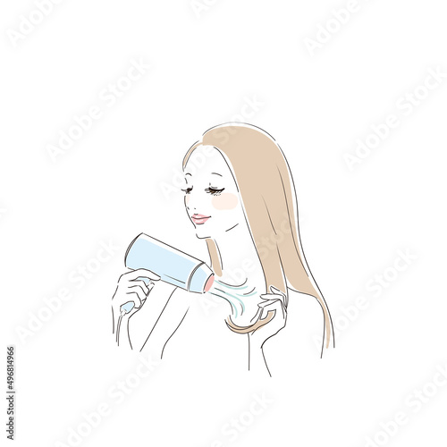 ヘアドライヤーで髪を乾かす美しい女性