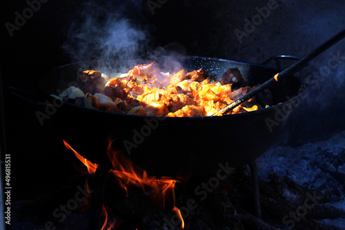 Closeup of a pan with migas and chorizo on the fire under the sunlight photo