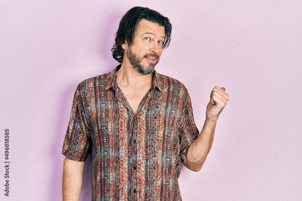 Middle age caucasian man wearing casual clothes smiling with happy face looking and pointing to the side with thumb up. Middle age caucasian man wearing casual clothes smiling with happy face looking and pointing to the side with thumb up.