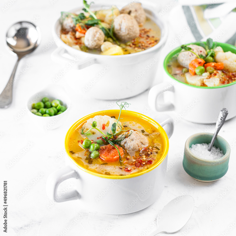 Step 4. Recipe for soup with meatballs, cauliflower, baby peas, carrots and cream on a white background. Square. Step 4. Recipe for soup with meatballs, cauliflower, baby peas, carrots and cream on a white background. Square.