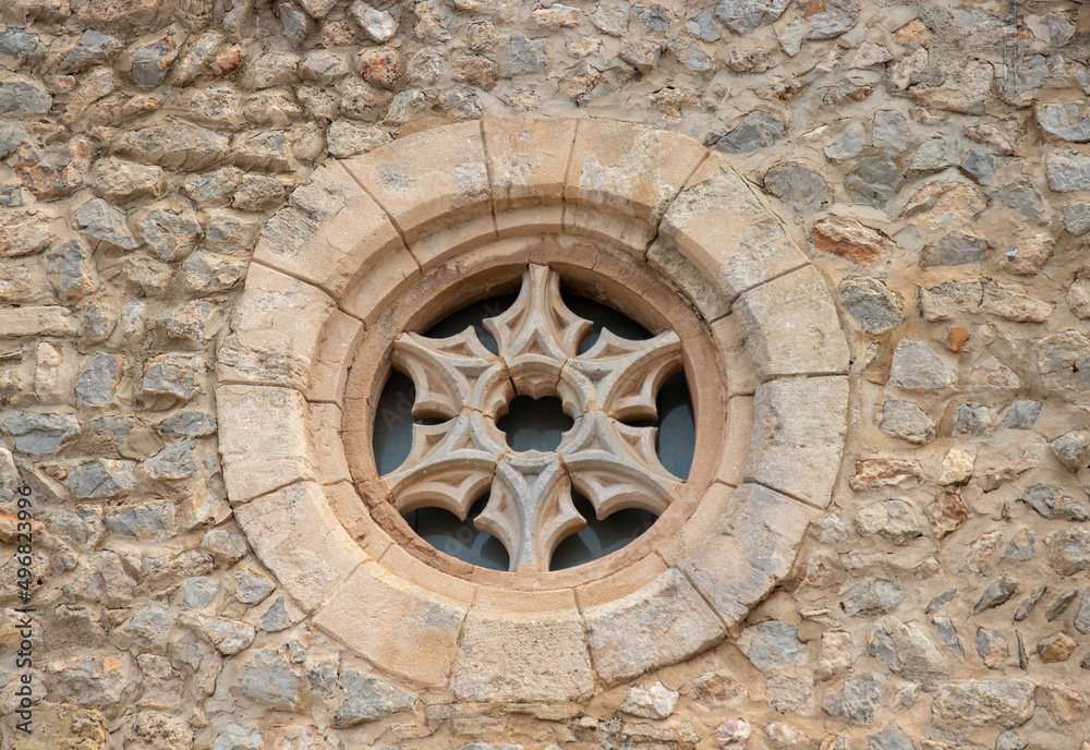 Ancient stone cross window on church in Ibiza